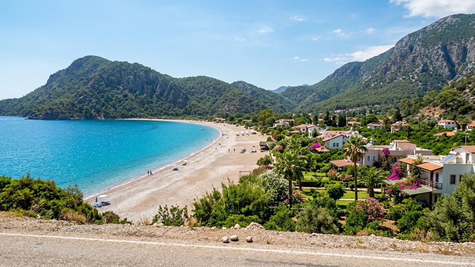 The pebble beach of Çıralı bay A long pebble beach at Çıralı, nestled in a green valley between wooded ridges with distant guesthouses.