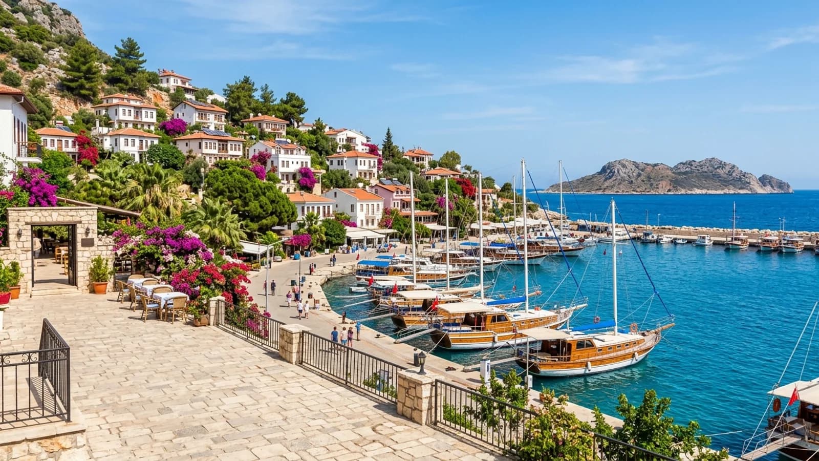 Der malerische Hafen von Kaş Holzboote im kleinen Hafen von Kaş vor weißen Häusern, die sich den Hang hinaufziehen.