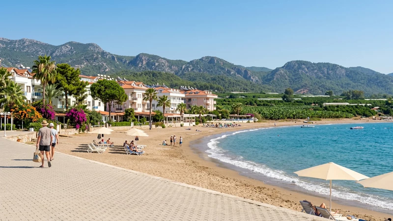 Strand und Hotels in Kızılağaç Sandstrand in Kızılağaç mit Resorthotels, grünen Plantagen an der Küste und fernen Bergen im Landesinneren.