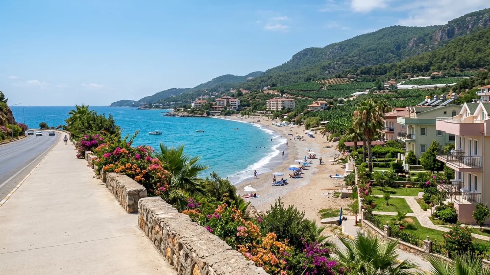 De rustige kust van Yeşilöz nabij Alanya Een smal strand onder de kustweg bij Yeşilöz, met bananenplantages en beboste heuvels erachter.